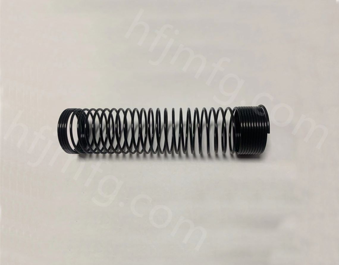 Steel compression spring with black surface coating and precision coil forming